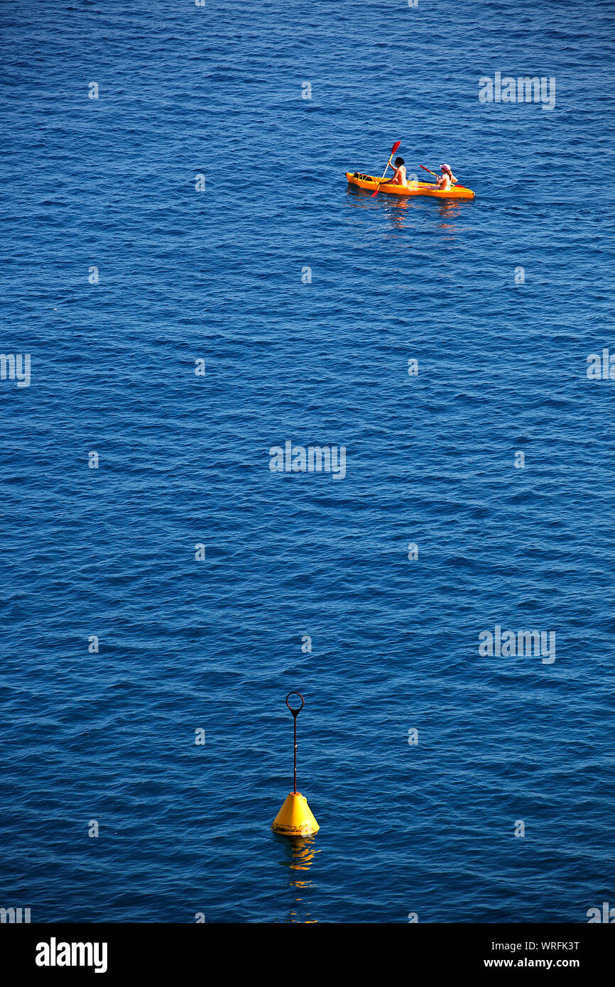High Angle View Of Buoy With People Boating On Sea Stock Photo