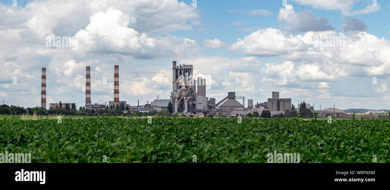 Pipes, buildings and production facilities of a cement plant. Panorama Stock Photo