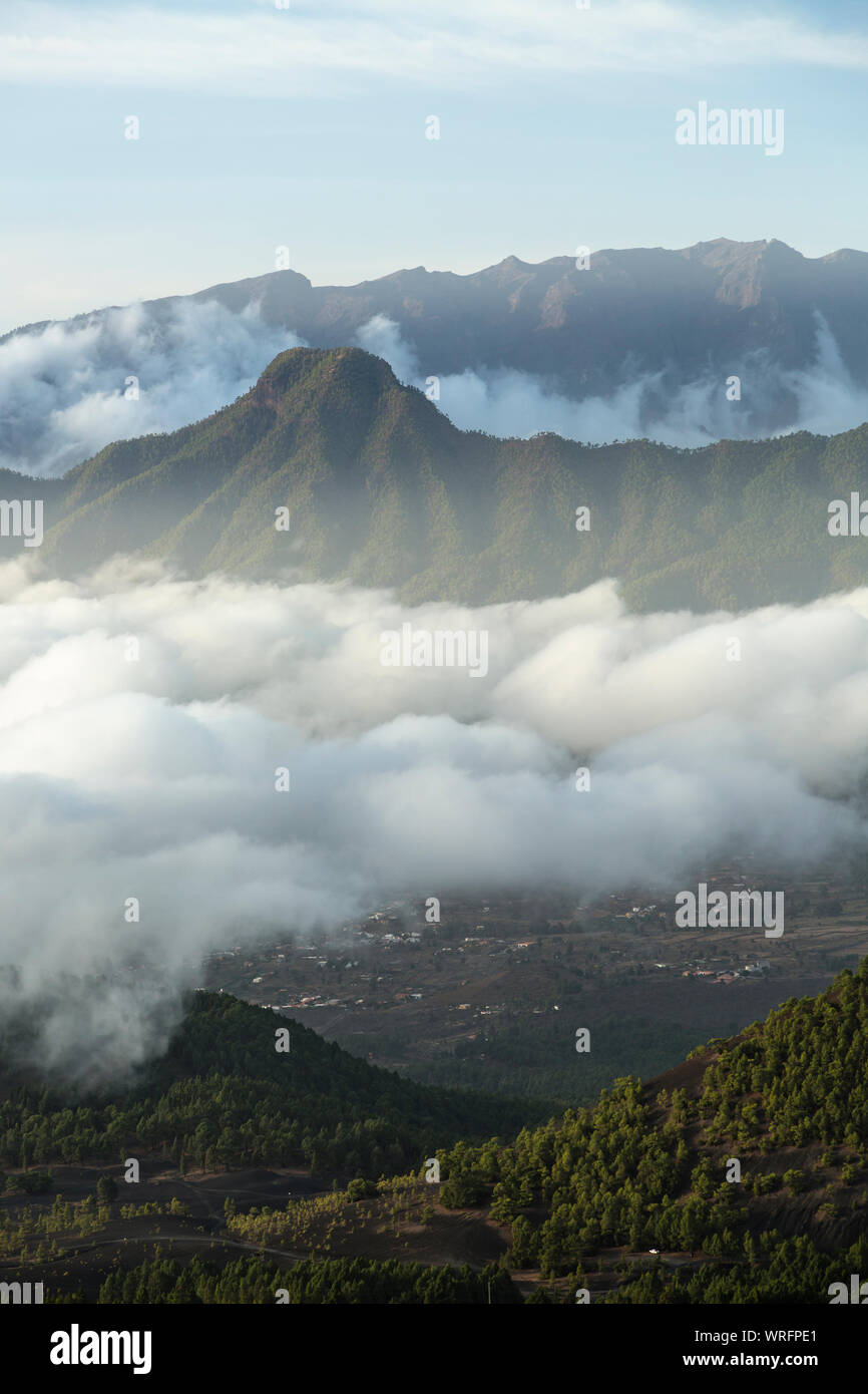 Evening view from the way to the Pico Birigoyo to the Pico Bejenado in La Palma, Spain and passat clouds in the valley. Stock Photo
