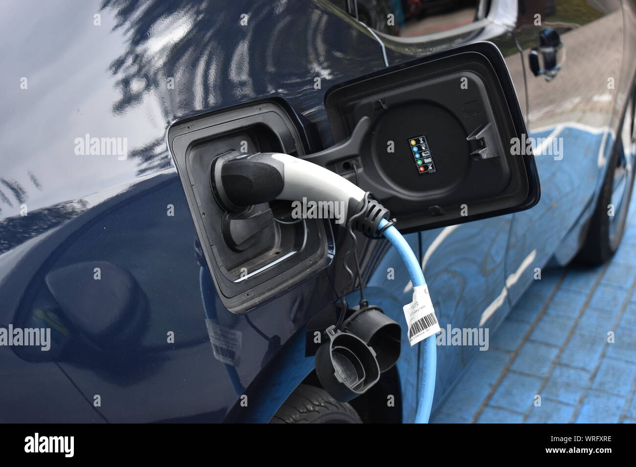 Electric vehicle plugged in to charge up Stock Photo