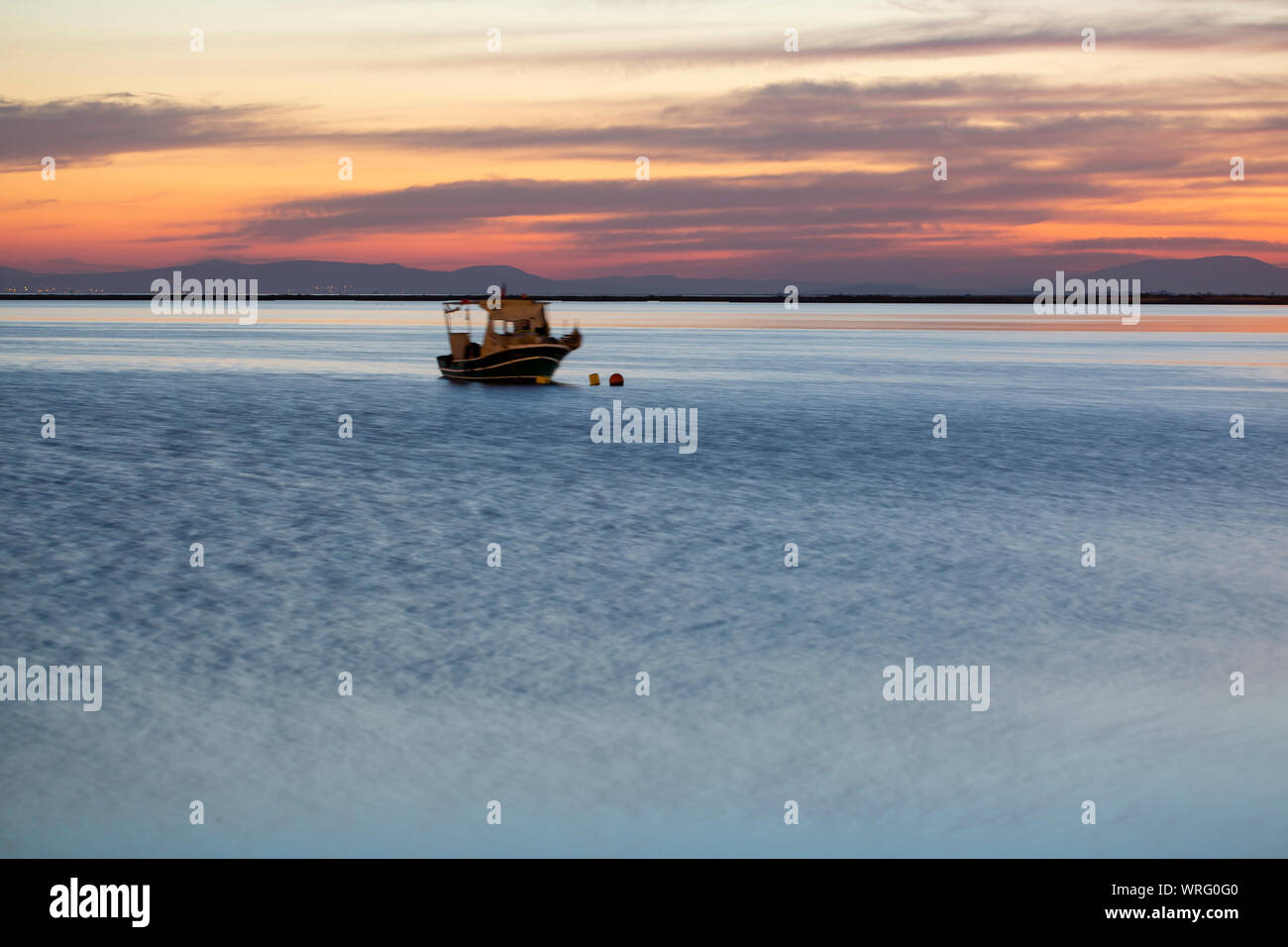 A Sailing Boat with Misty Sunset and Reflection on Water Stock Photo ...