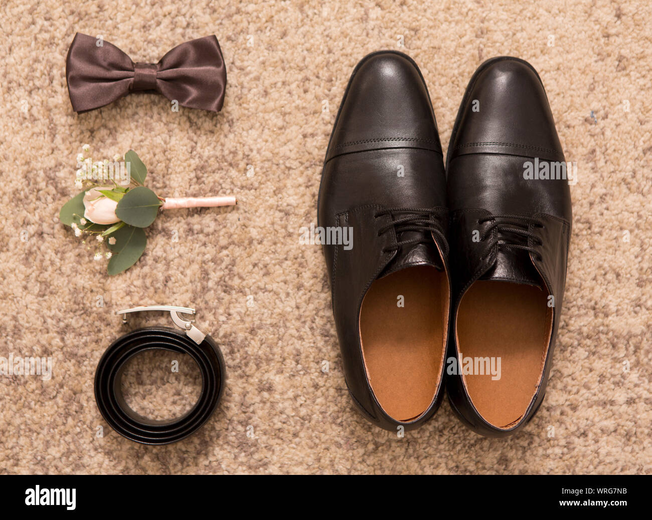 Groom accessories and black shoes on brown background Stock Photo