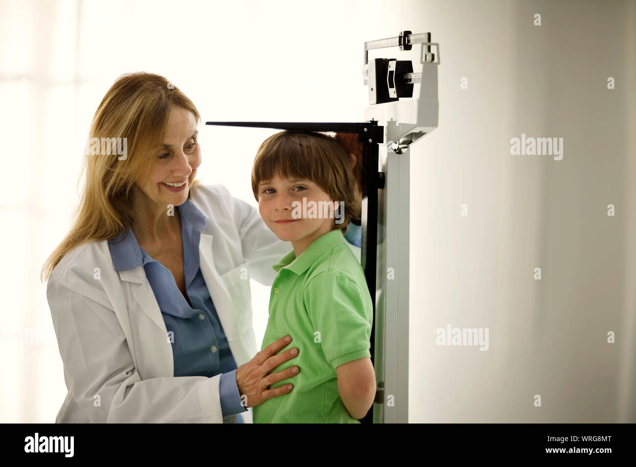 Doctor measuring a young boy's height. Stock Photo