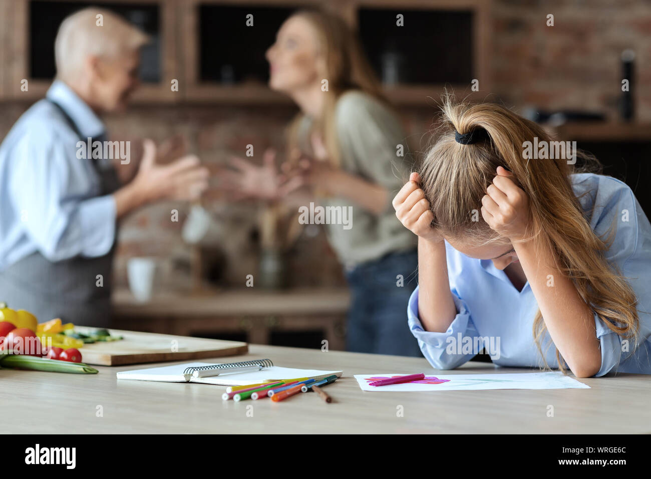 Upset girl crying while her mom and granny fighting Stock Photo