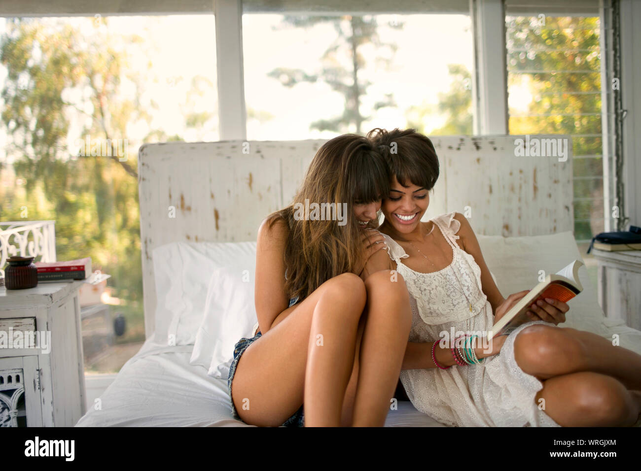 Two women reading a book Stock Photo