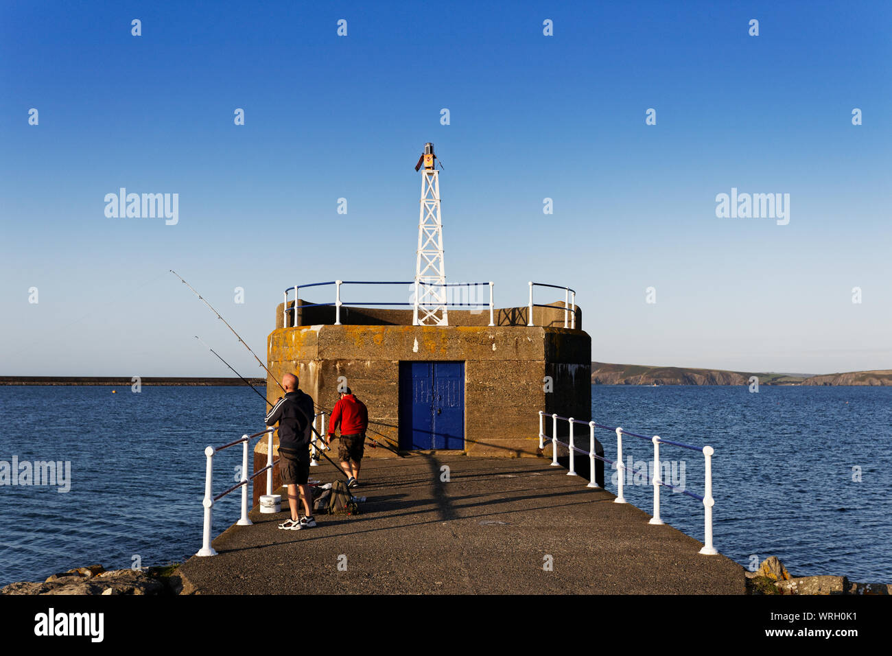 Fishermen on the promenade wall in Fishguard, Wales, UK. Wednesday 28 August 2019 Stock Photo