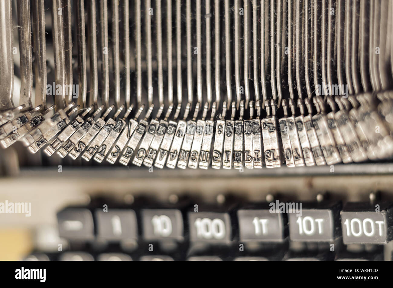 Carriage block with letters in an old mechanical typewriter. Close-up, open aperture. Stock Photo