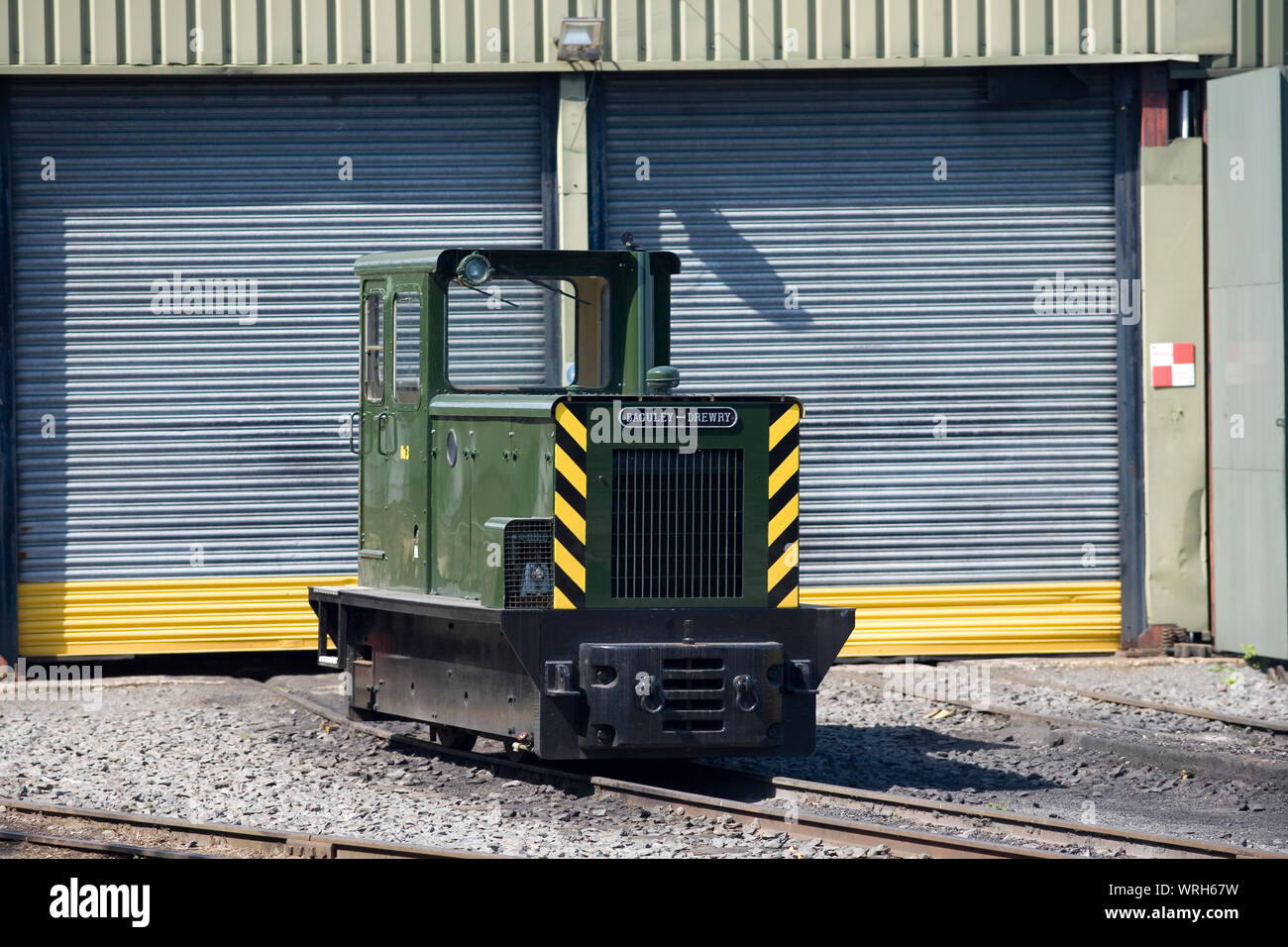 green Baguley Drewry shunter outside engine shed on warm summer day at Whipsnade zoo Stock Photo