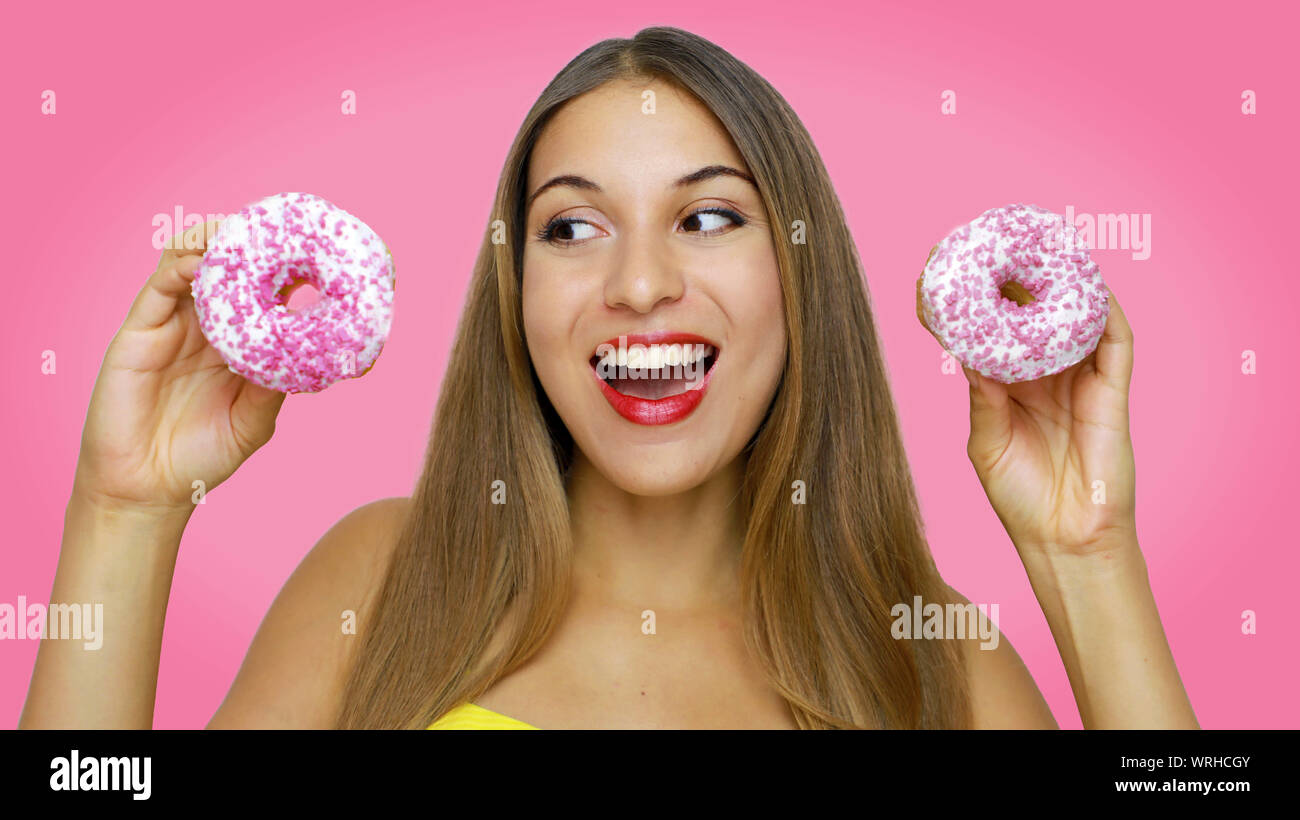 Happy Cheerful Excited Young Woman Holding Two Donuts In Her Hands Looking To The Side On Pink 5652