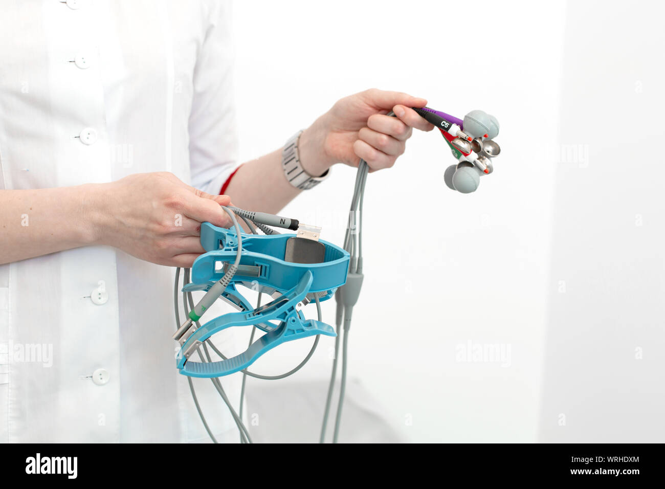 The cardiologist holds the electrocardiograph sensors in his hands ...