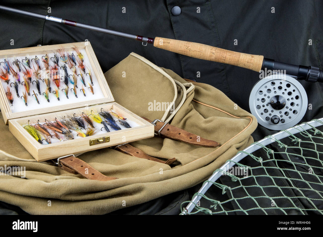 Fly fishing tackle with bag and net on outdoor coat Stock Photo - Alamy