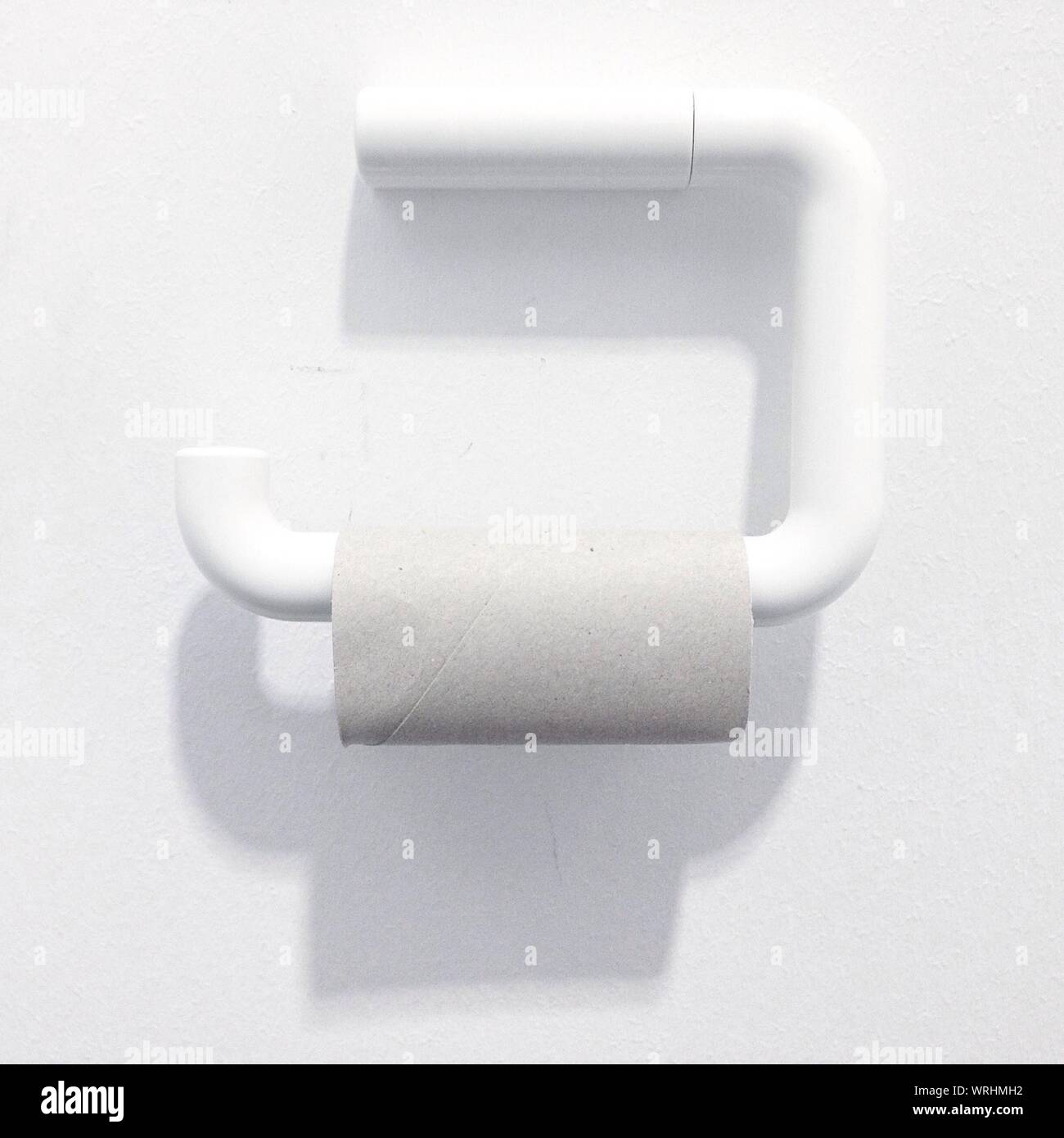 Empty Toilet Paper Roll On Holder Against White Wall Stock Photo Alamy