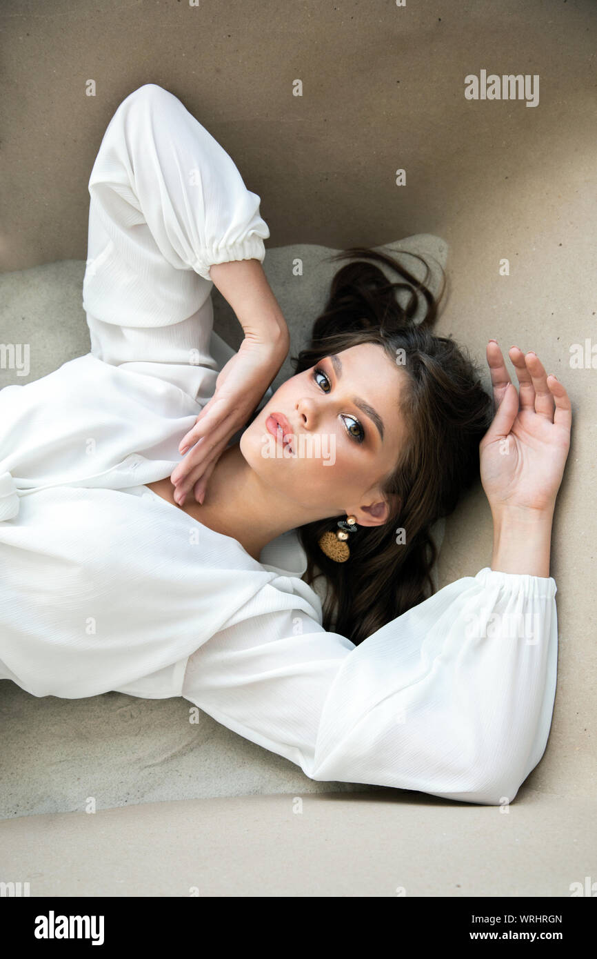 Portrait of sensual brunette model lying in a bath of sand Stock Photo