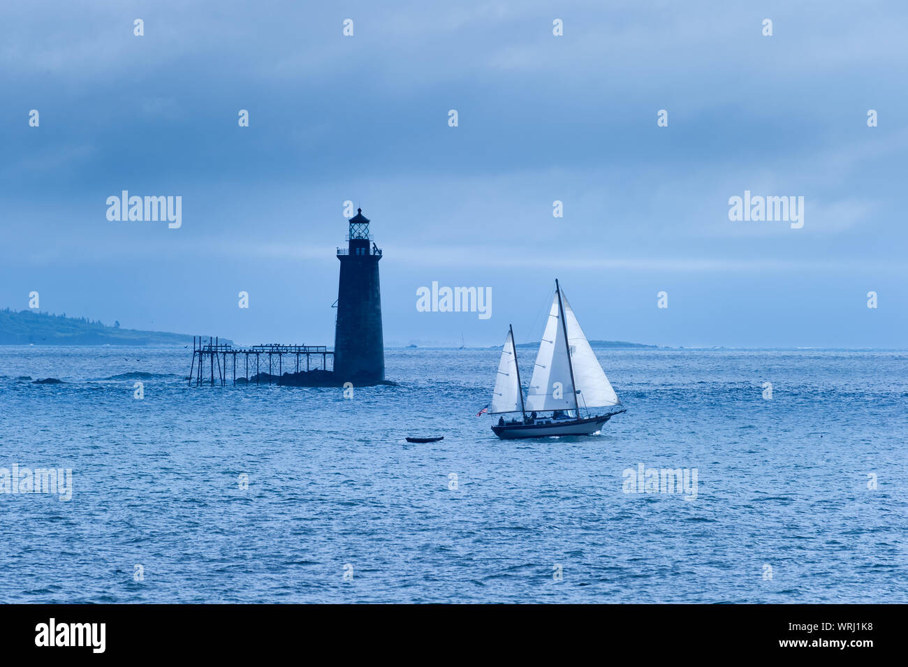 Large sailboat passing by Ram Island Ledge Lighthouse in Portland