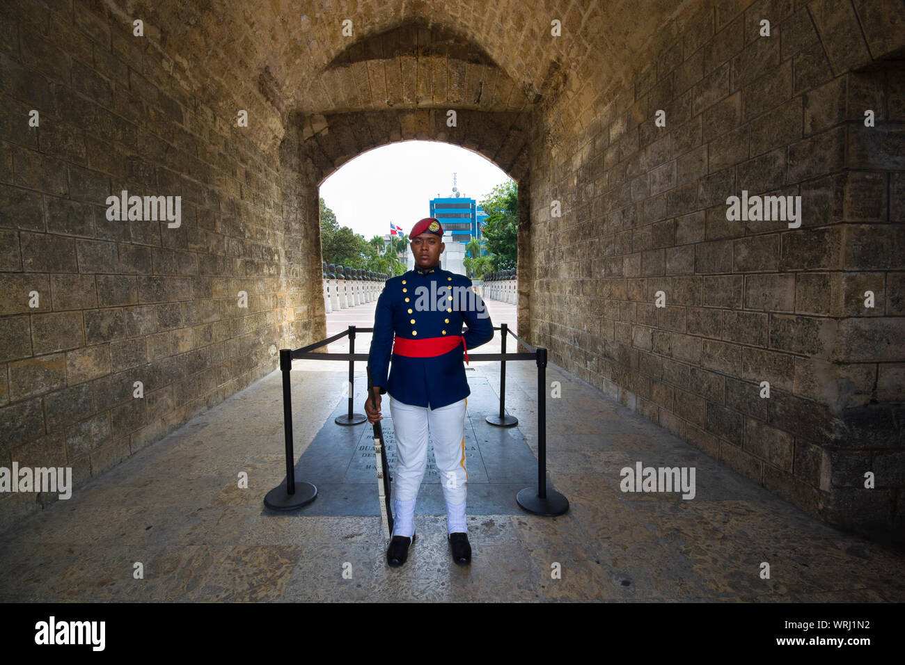 SANTO DOMINGO, DOMINICAN REPUBLIC - JUNE 26, 2019: Armed guard in La Puerta del Conde (Count's Gate), behind there is Independence Park and Altar of t Stock Photo