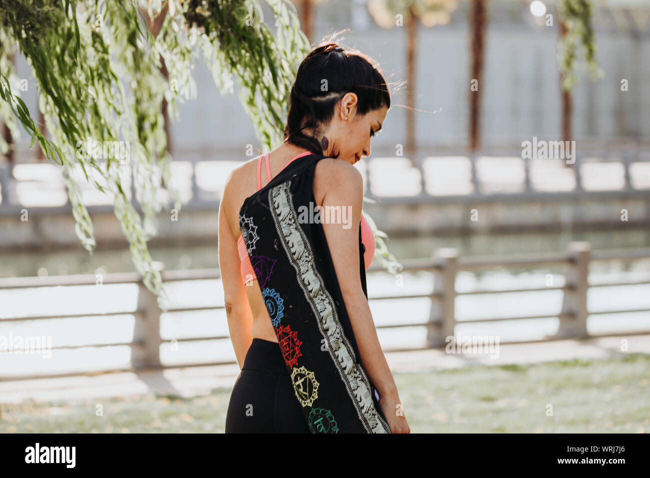 Latin Woman Prepares for Yoga Session with Shoulder Mat. Stock Photo