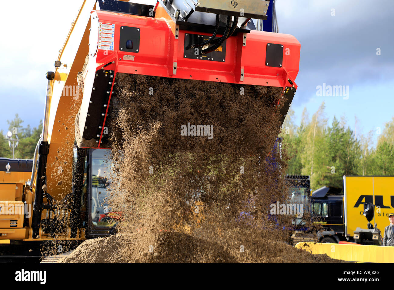 Hyvinkaa, Finland. September 6, 2019. Excavator mounted ALLU D Transformer hydraulic screener bucket attachment screening earth on Maxpo 2019. Stock Photo