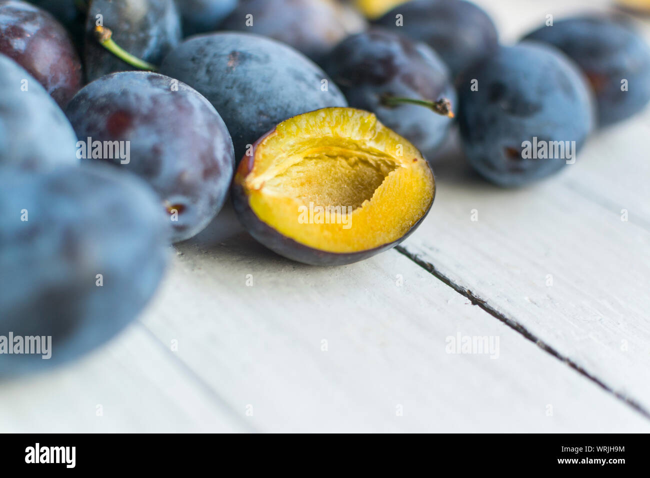 Freshly picked and delicious blue plums on wooden table with copy space ...