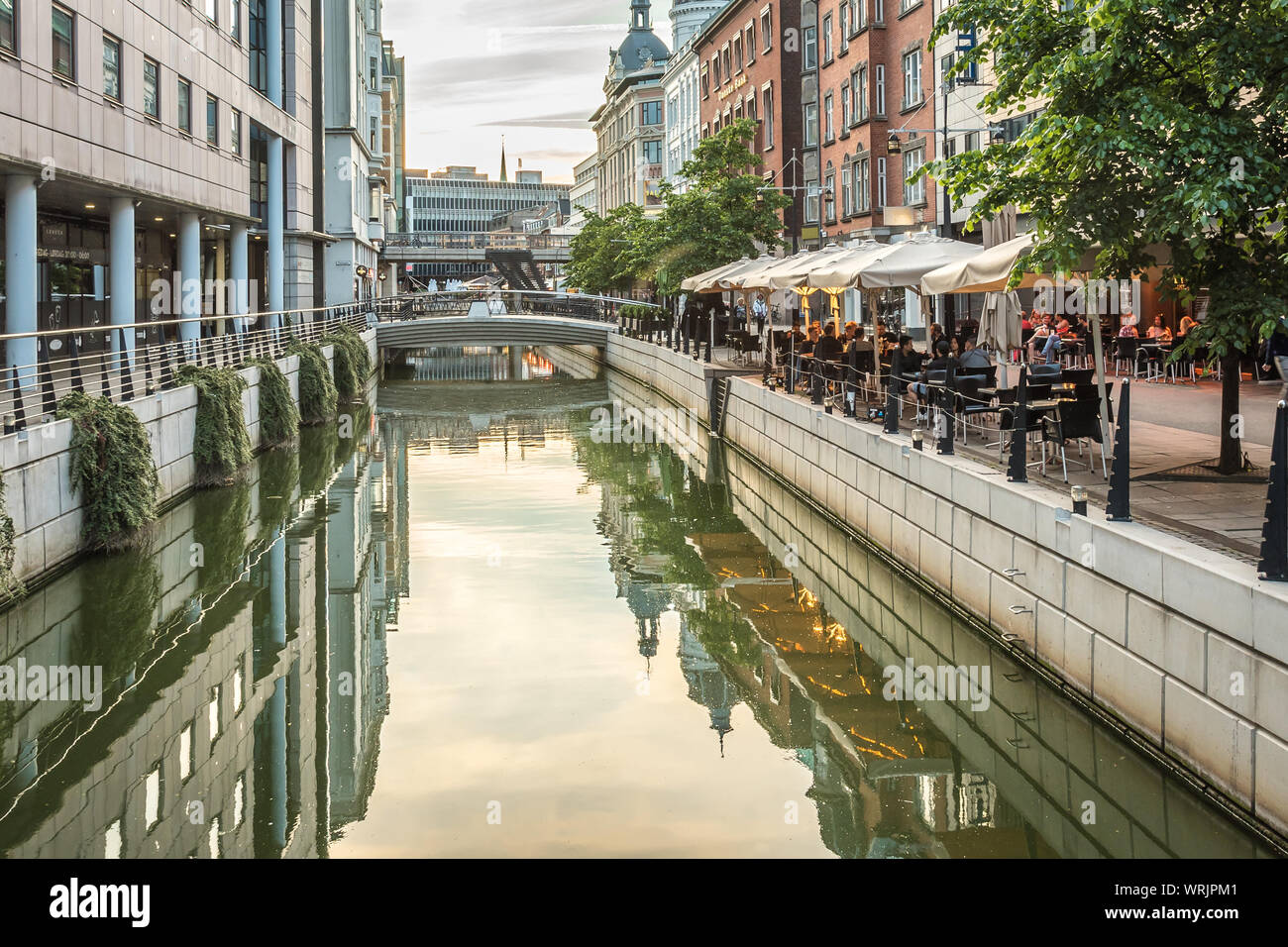 Downtown Aarhus with the canal and restaurants in the evening, reflecting in the water, Denmark, July 15, 2019 Stock Photo