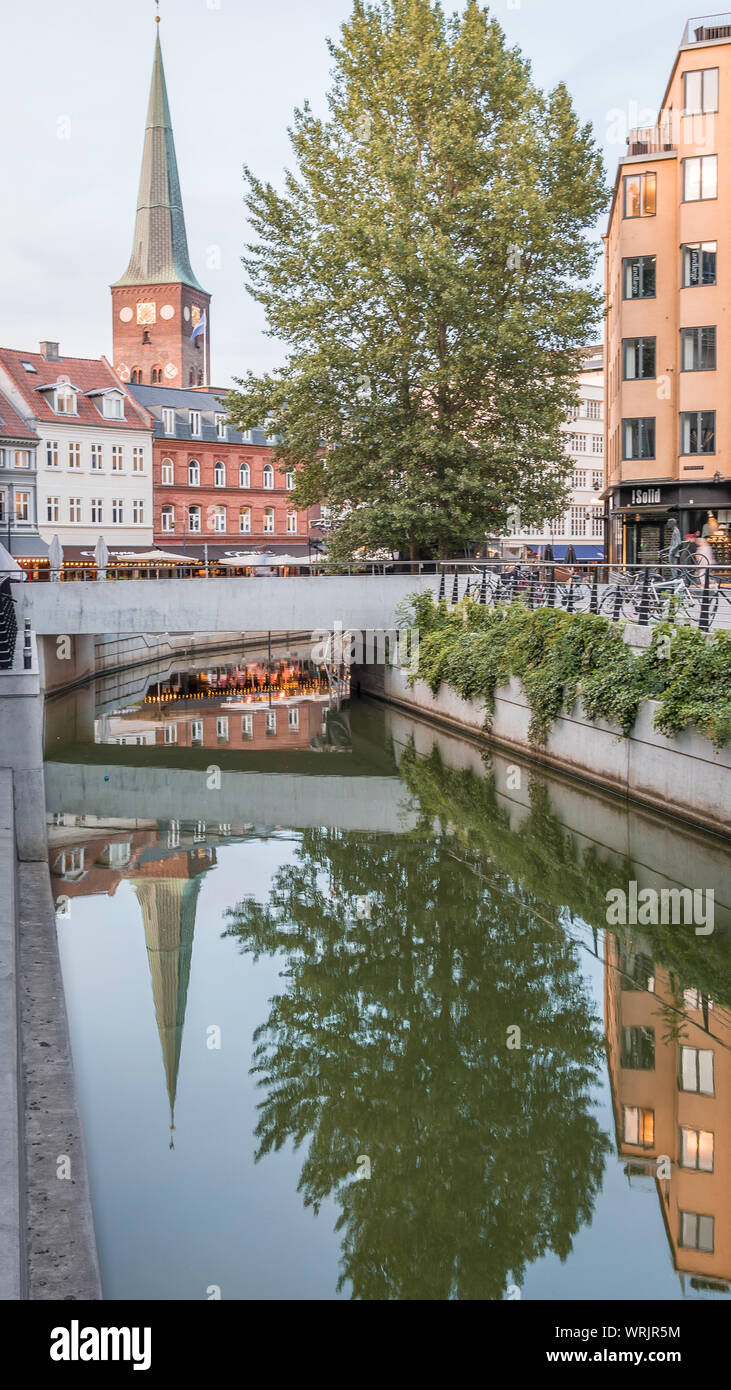 The Aarhus cathedral spire, reflecting in the calm water of the canal, Denmark, July, 15, 2019 Stock Photo