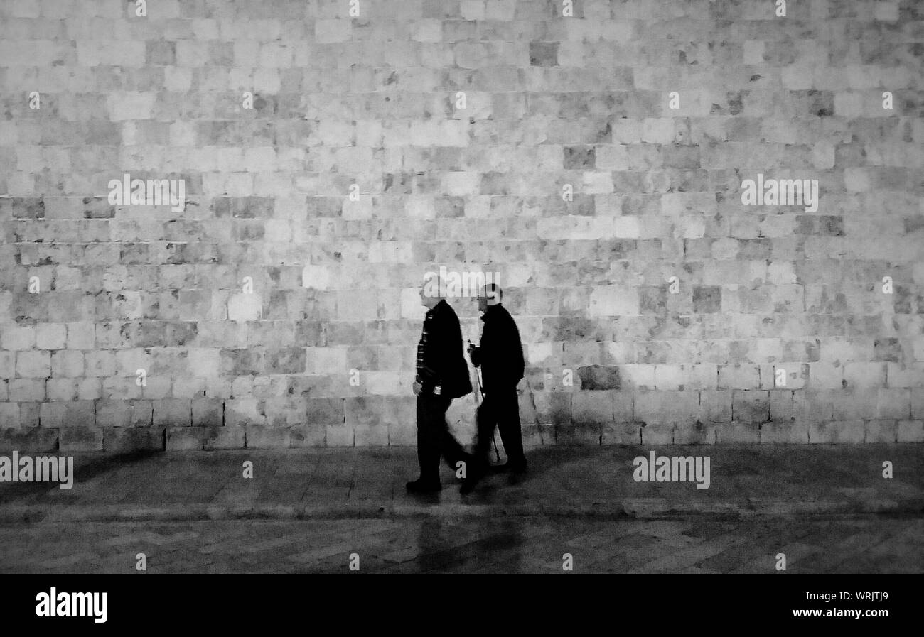 Senior Men Walking Against Wall Stock Photo