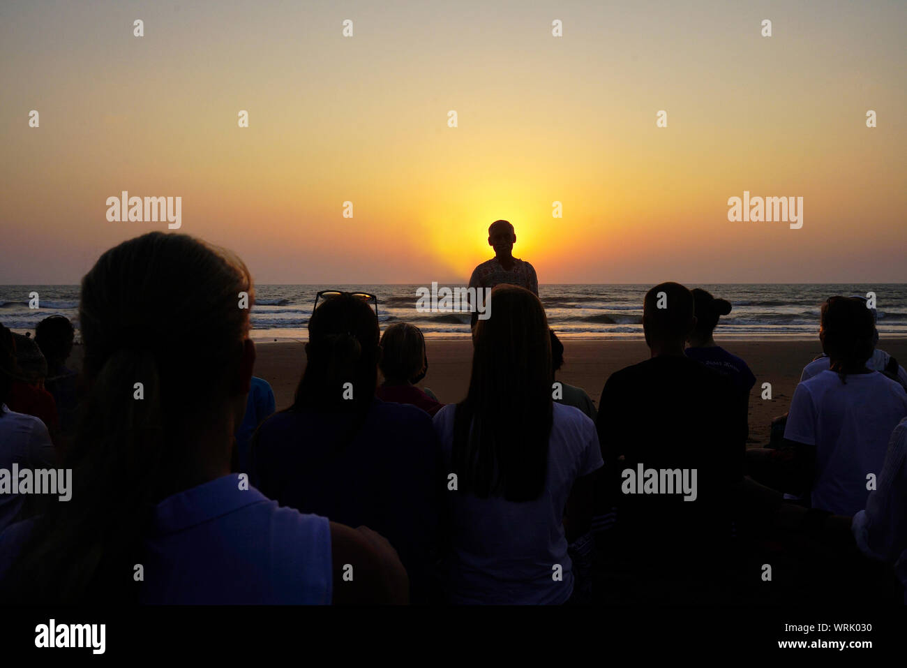Yoga teacher   and practicing yoga on   beach of  South  India . Unrecognizable persons Stock Photo
