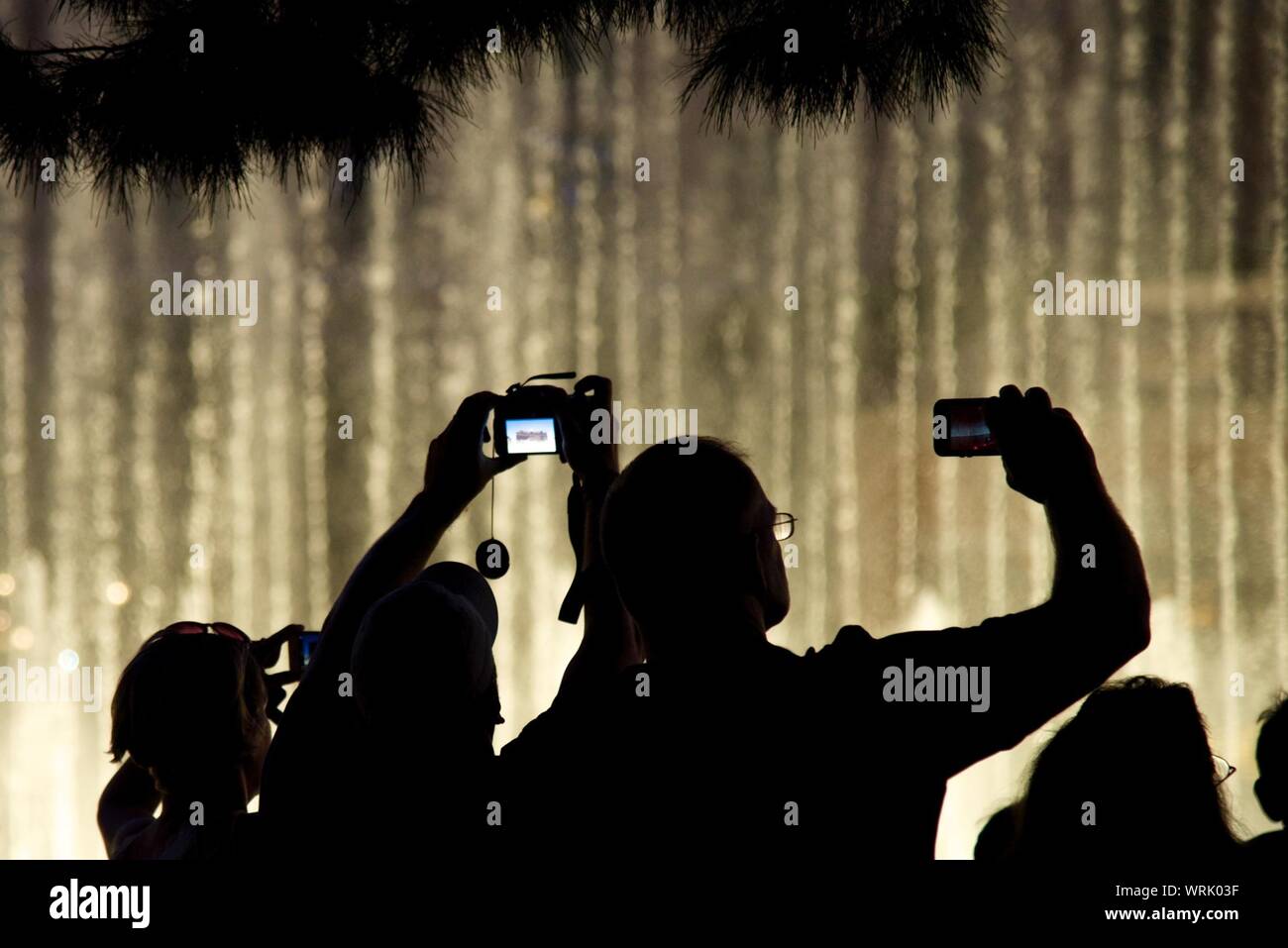 Rear View Of People Clicking Photograph Of Lights Stock Photo