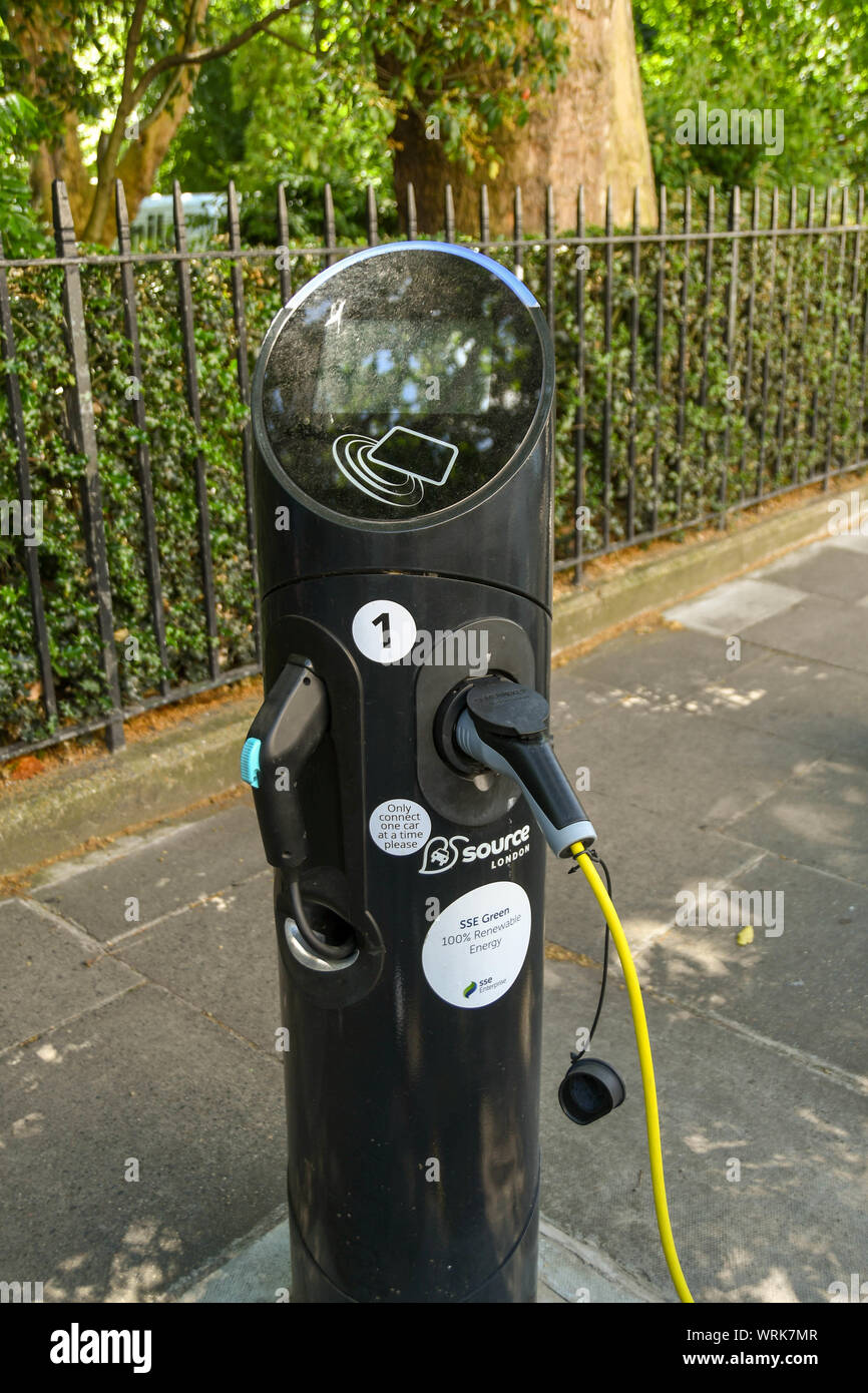 LONDON, ENGLAND - JULY 2018:  Close up view of a charging point for electric cars in central London. A car charging lead is plugged in. Stock Photo