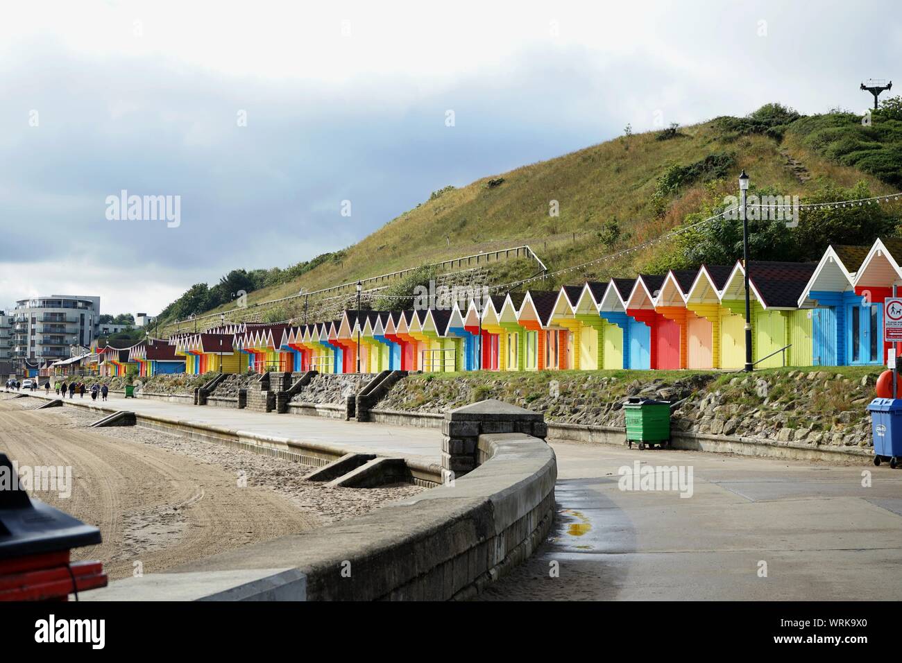 The colourfull beach huts at the north bay in Scarborough with the promenade and sandy beach Scarborough Yorkshire England Stock Photo