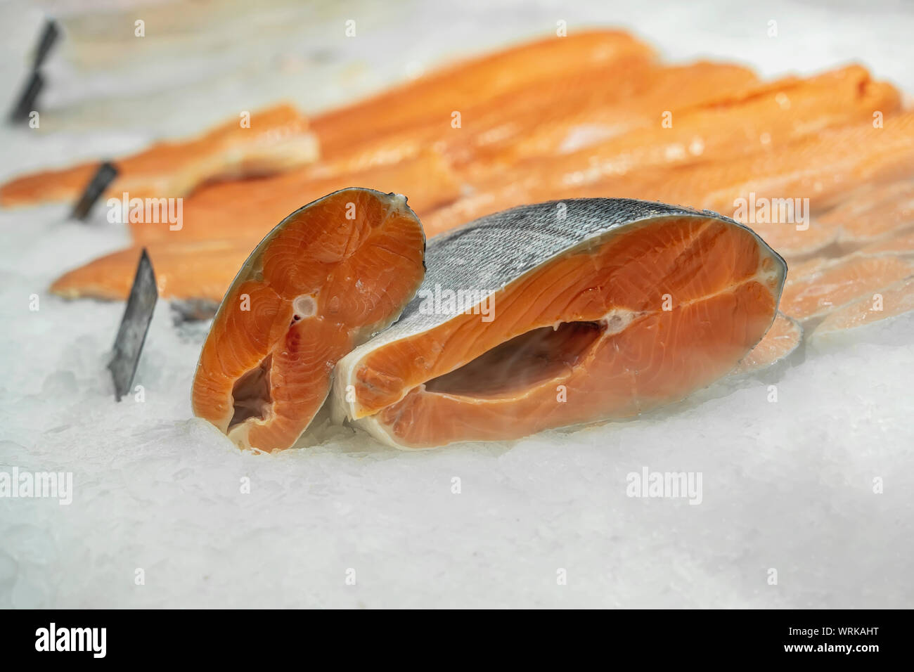 Pieces and fillet of salmon to portions on ice in supermarket close-up ...