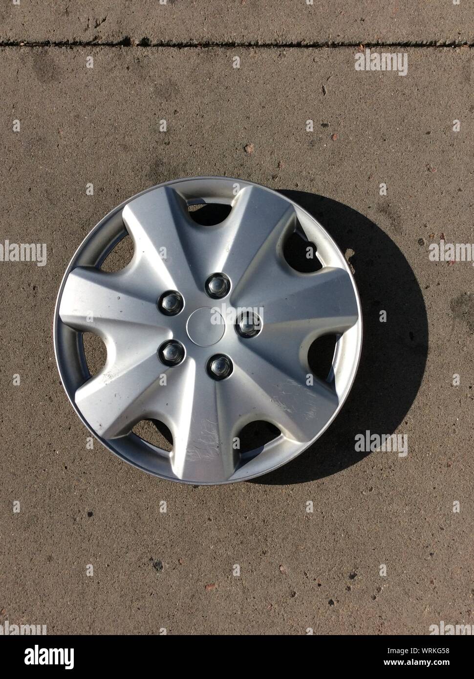 High Angle View Of Hubcap On Footpath Stock Photo