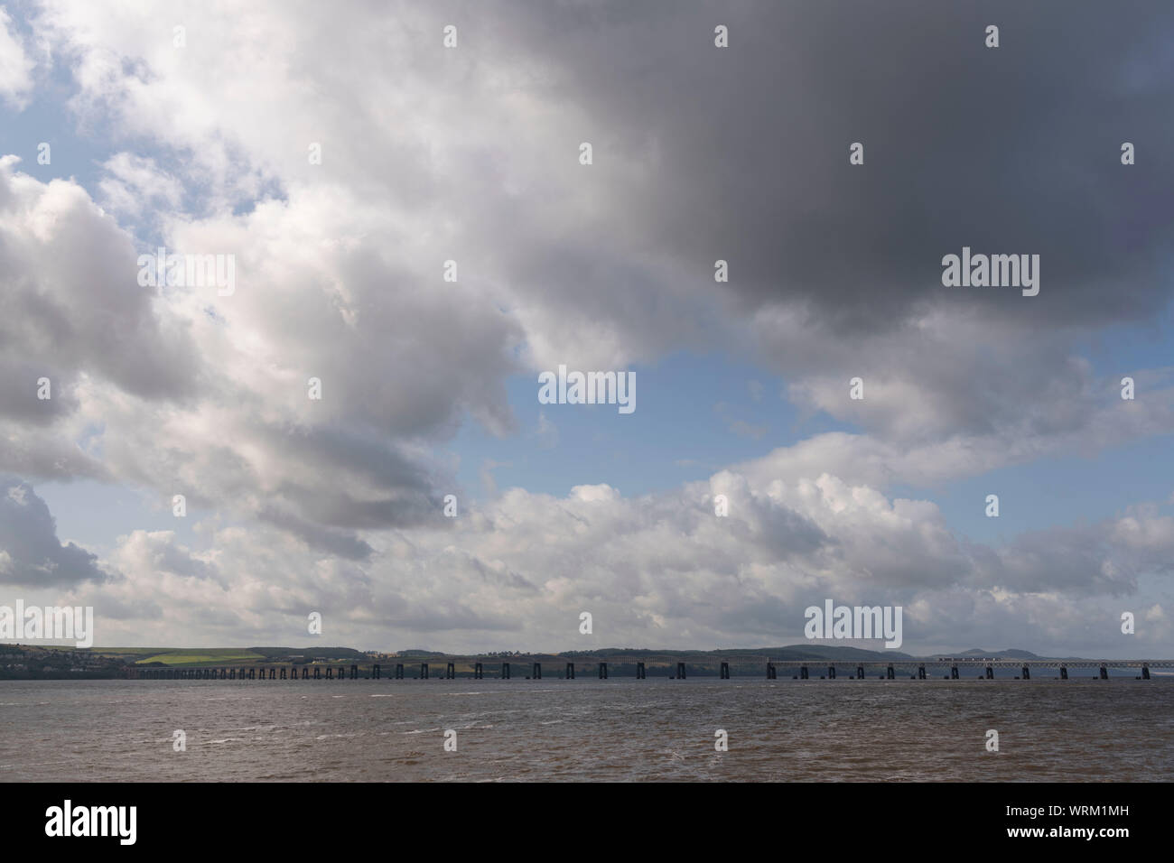 A Local Passenger Train Crosses the Firth of Tay on the Tay Railway Bridge, Seen from the Waterfront in Dundee Stock Photo