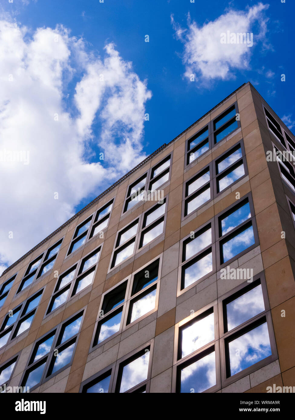 Cloudy sky reflected in the glass wall of a high building Stock Photo ...