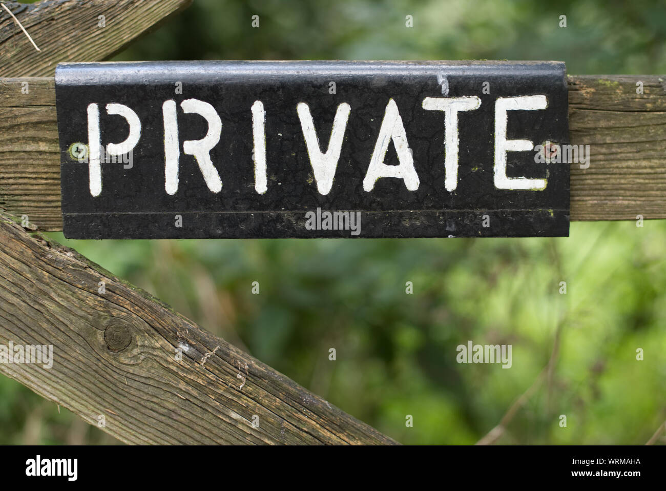 Old Private sign on wooden gate with greenery background. Keep out ...