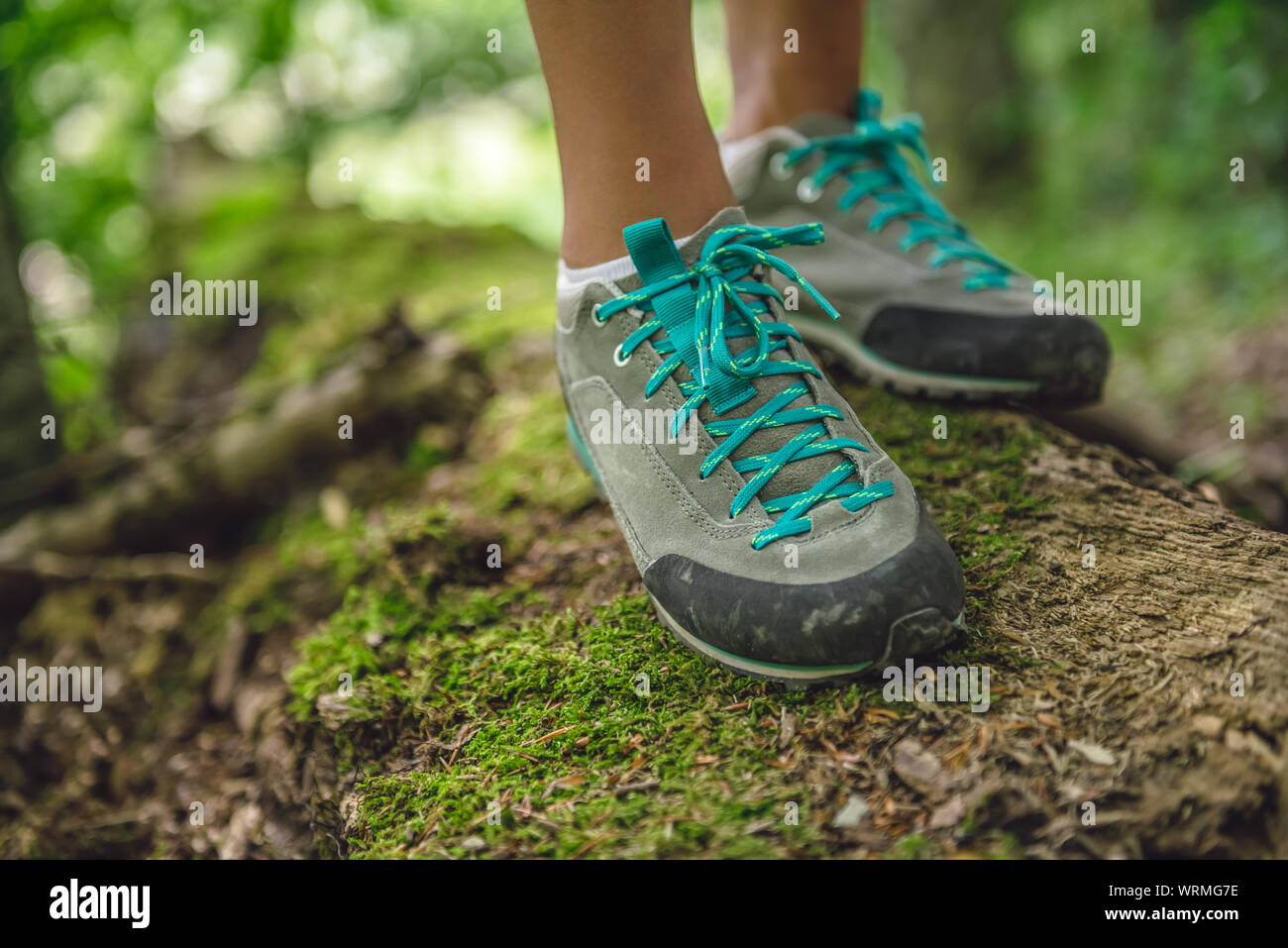 Hiker boots on tree log covered with moss Stock Photo