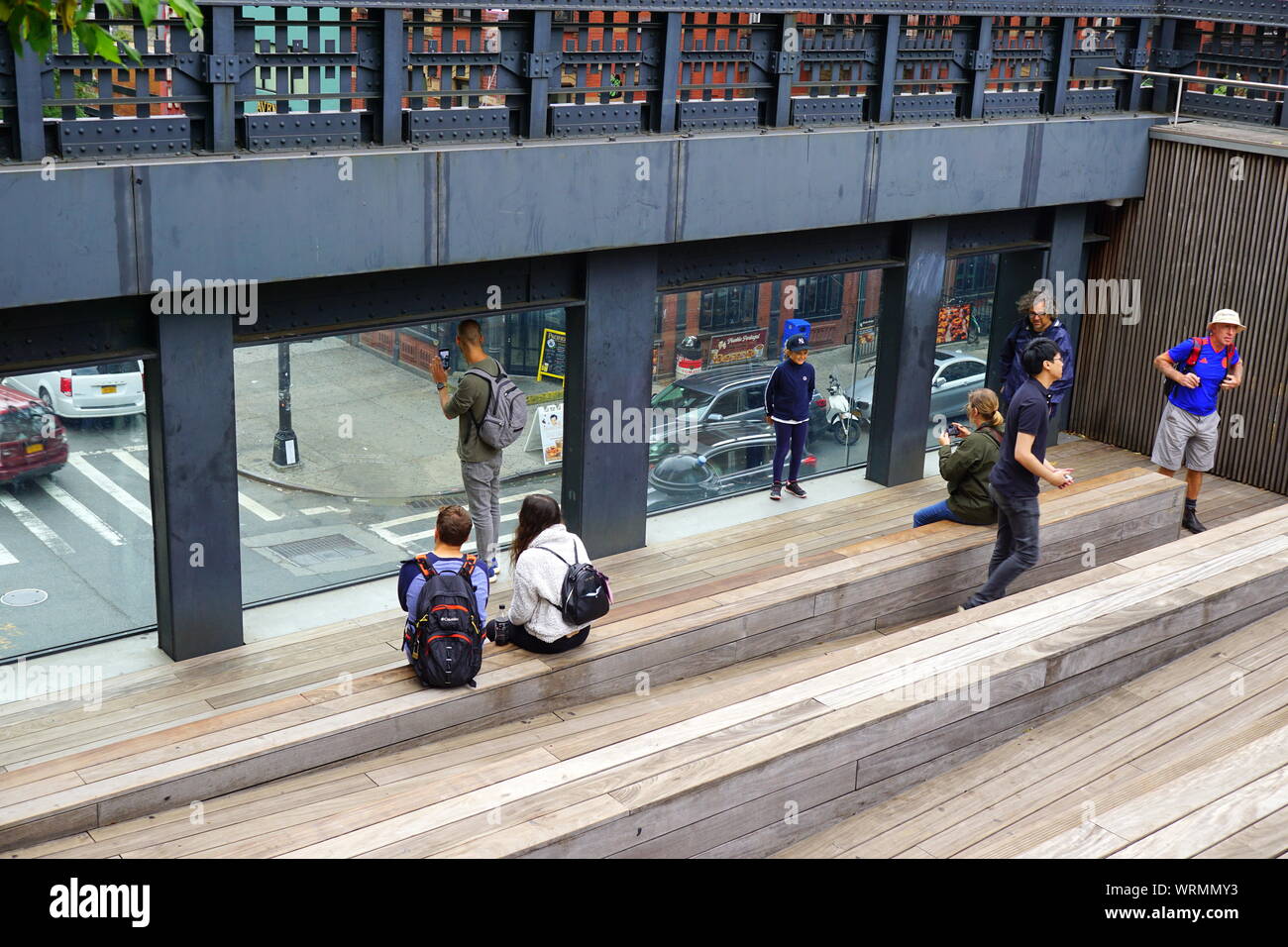 Visitors resting and enjoying the New York City street view at the High Line sitting steps Stock Photo