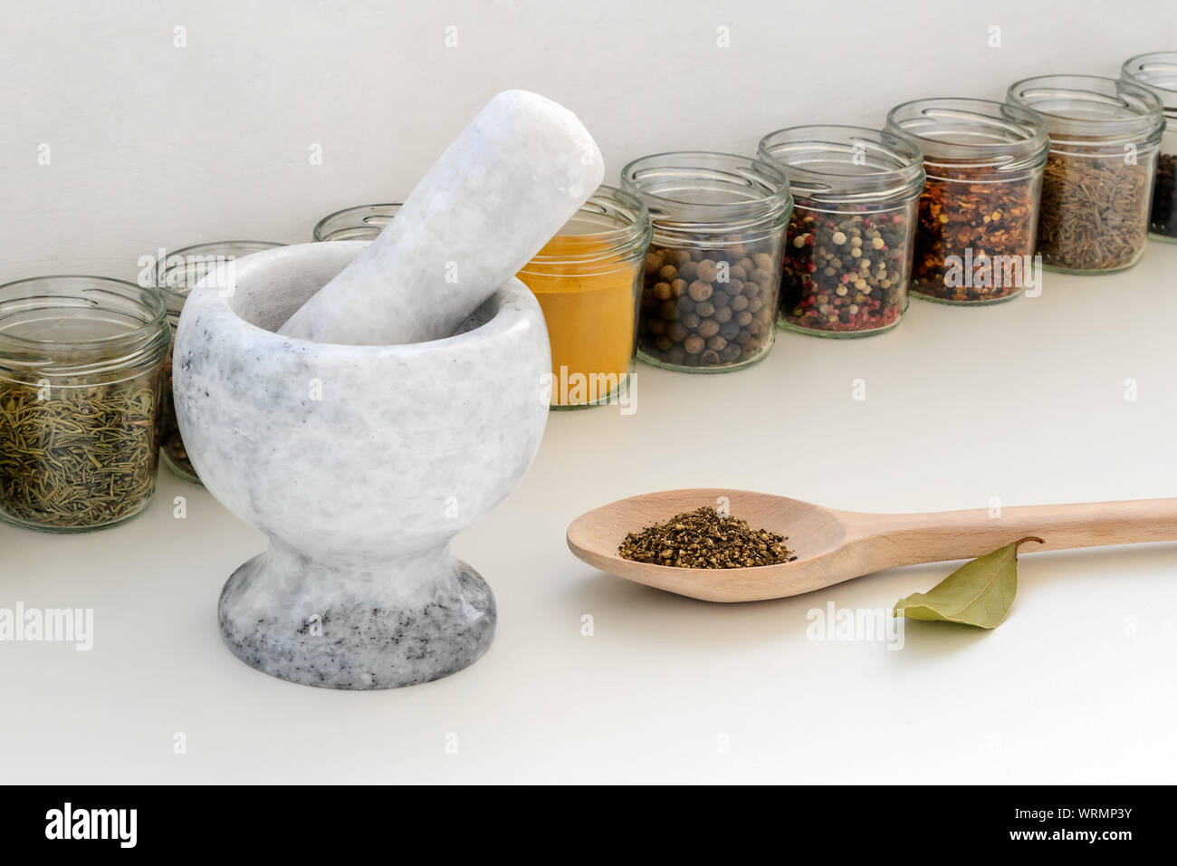Stone mortar with pestle, large wooden spoon with ground pepper and