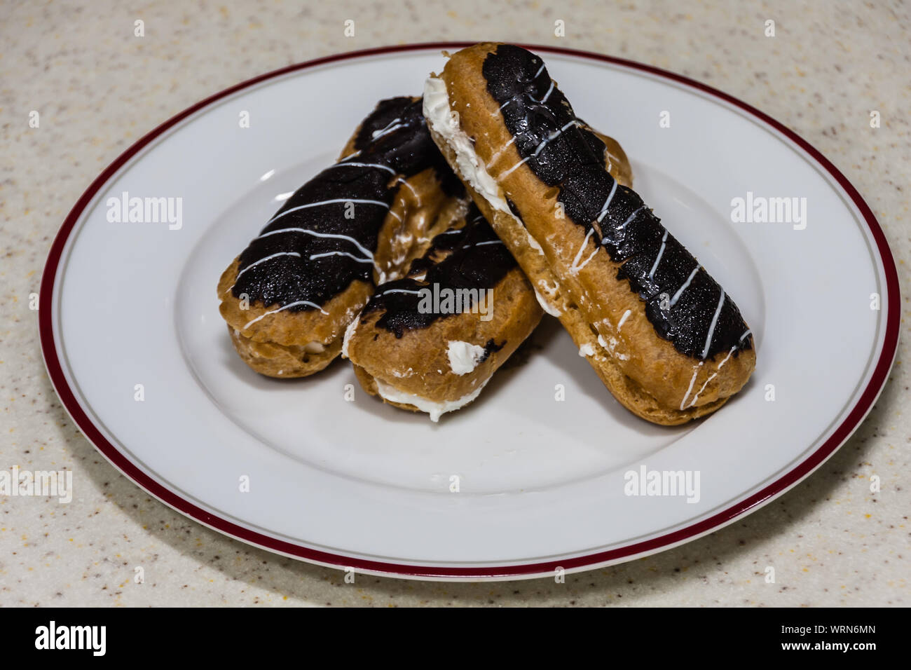 Freshly baked eclairs on a white plate Stock Photo