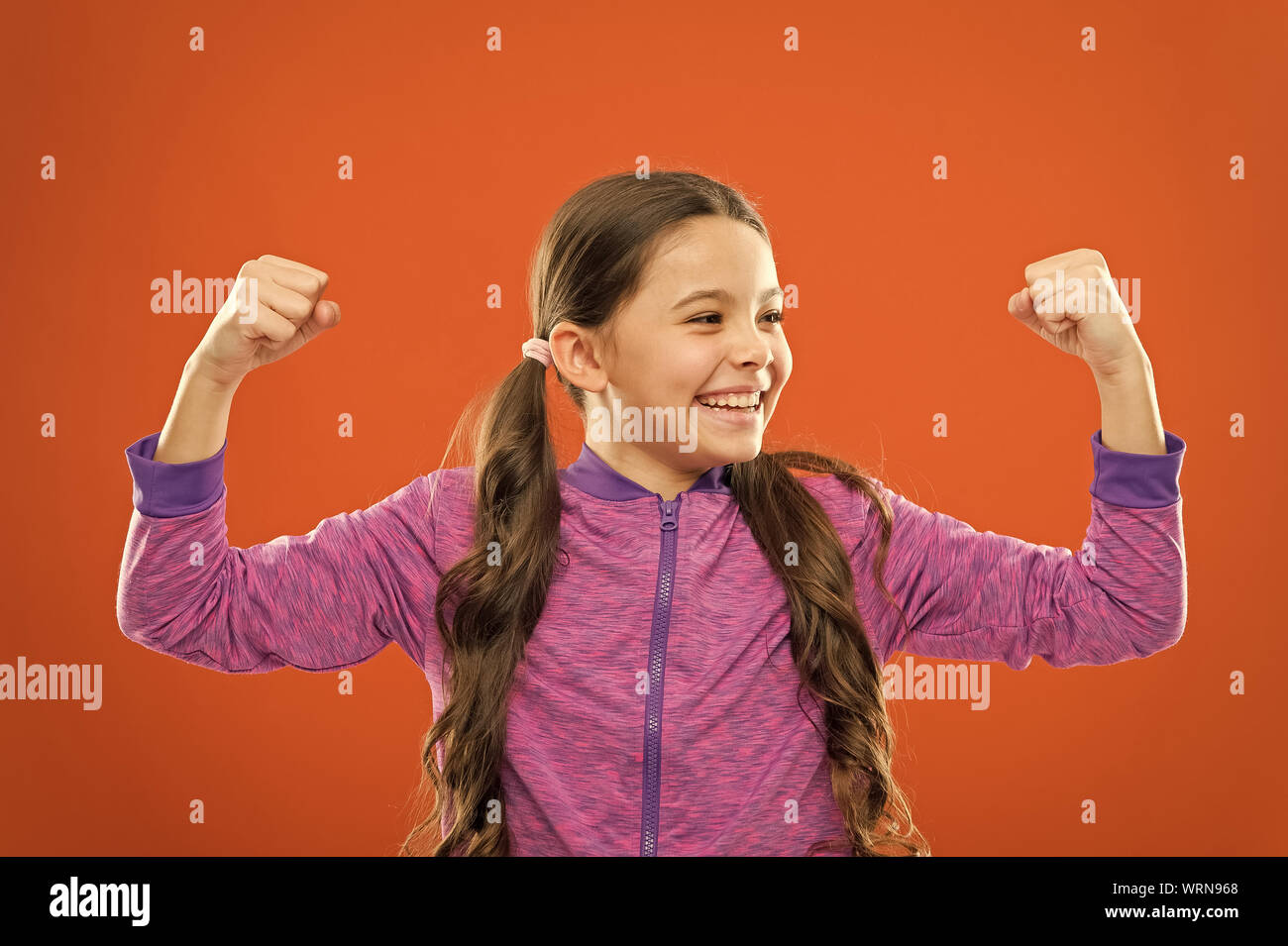 Feeling strong. Child cute girl show biceps power and strength. Girls