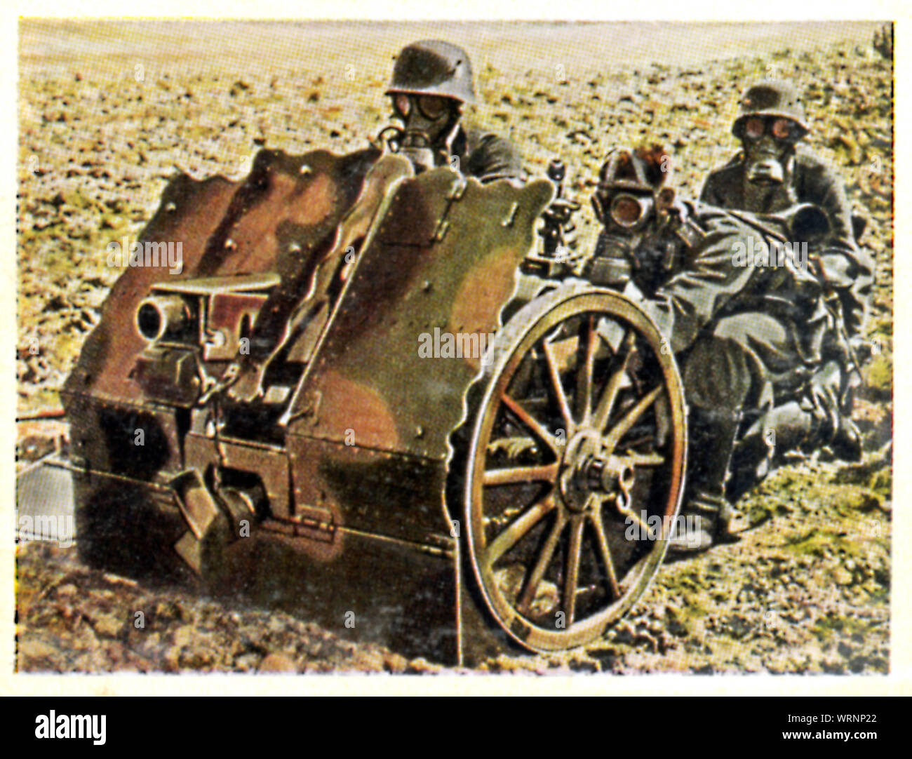 Wehrmacht Light Gun Firing Position, 1936 cigarette card of German soldiers in gas masks training with a 7.5 cm infantry support gun Stock Photo