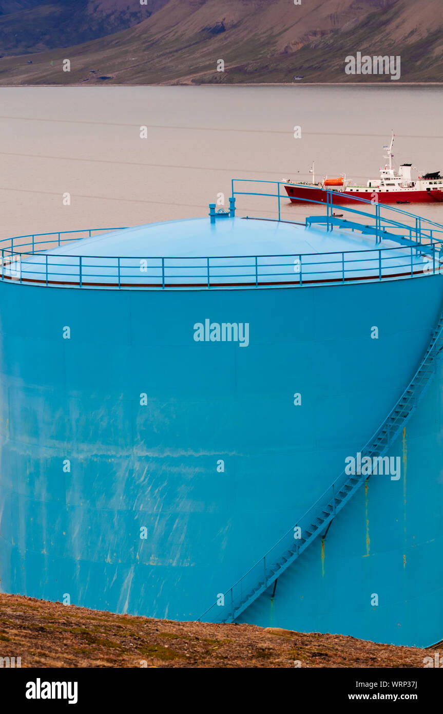 Colorful fuel storage tanks with a shipin the background on the