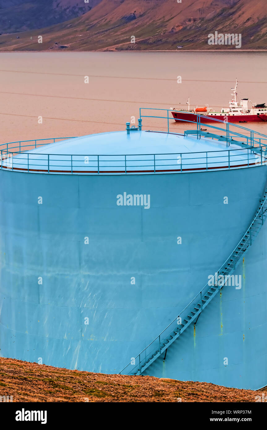 Colorful fuel storage tanks with a shipin the background on the