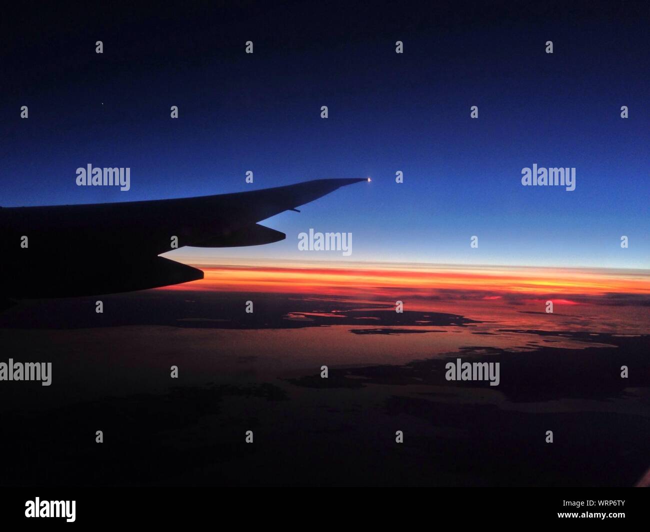 Wing of an airplane with clouds at sunset hi-res stock photography and ...