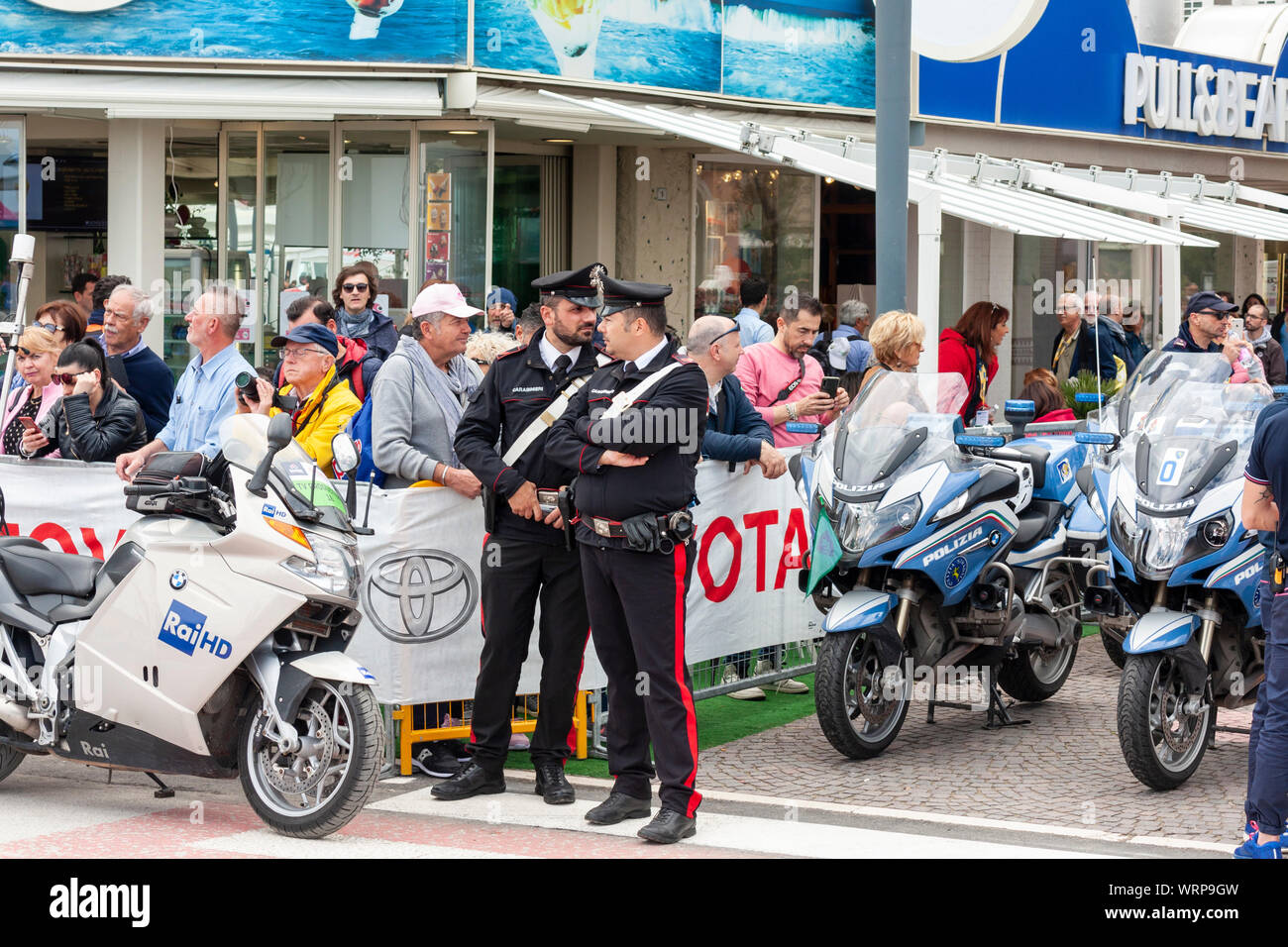 Two policemen chatting in front of the crowd before stage nine of the 2019 Giro d'Italia. Riccione, Italy Stock Photo