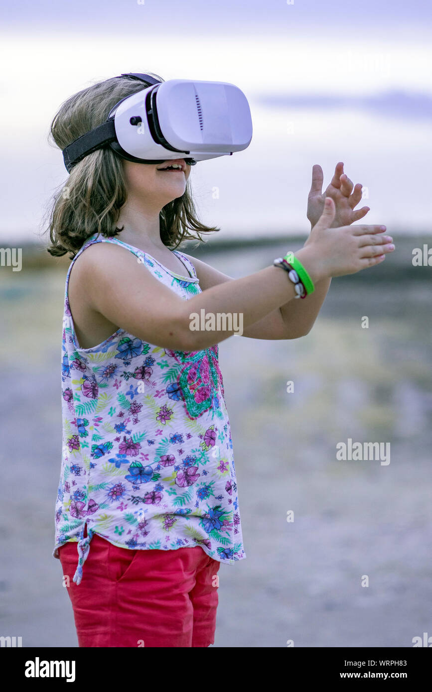 Little girl playing with a virtual reality glasses Stock Photo - Alamy