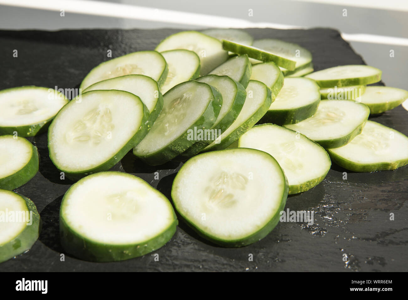 Slices of cucumber on the black cutting board Stock Photo - Alamy