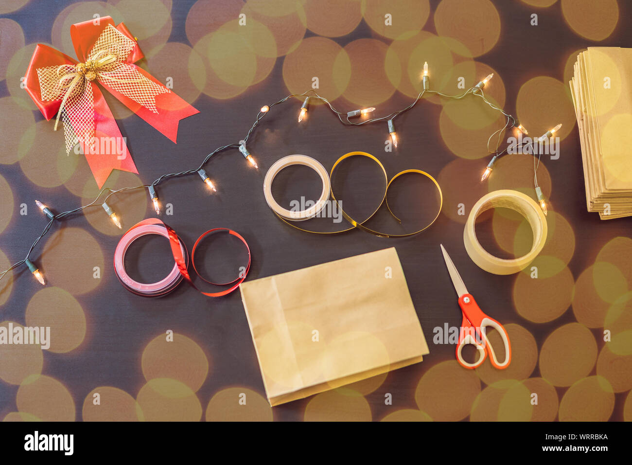 flat lay with christmas present, wrapping paper, ribbon and scissors on a black table Stock ...