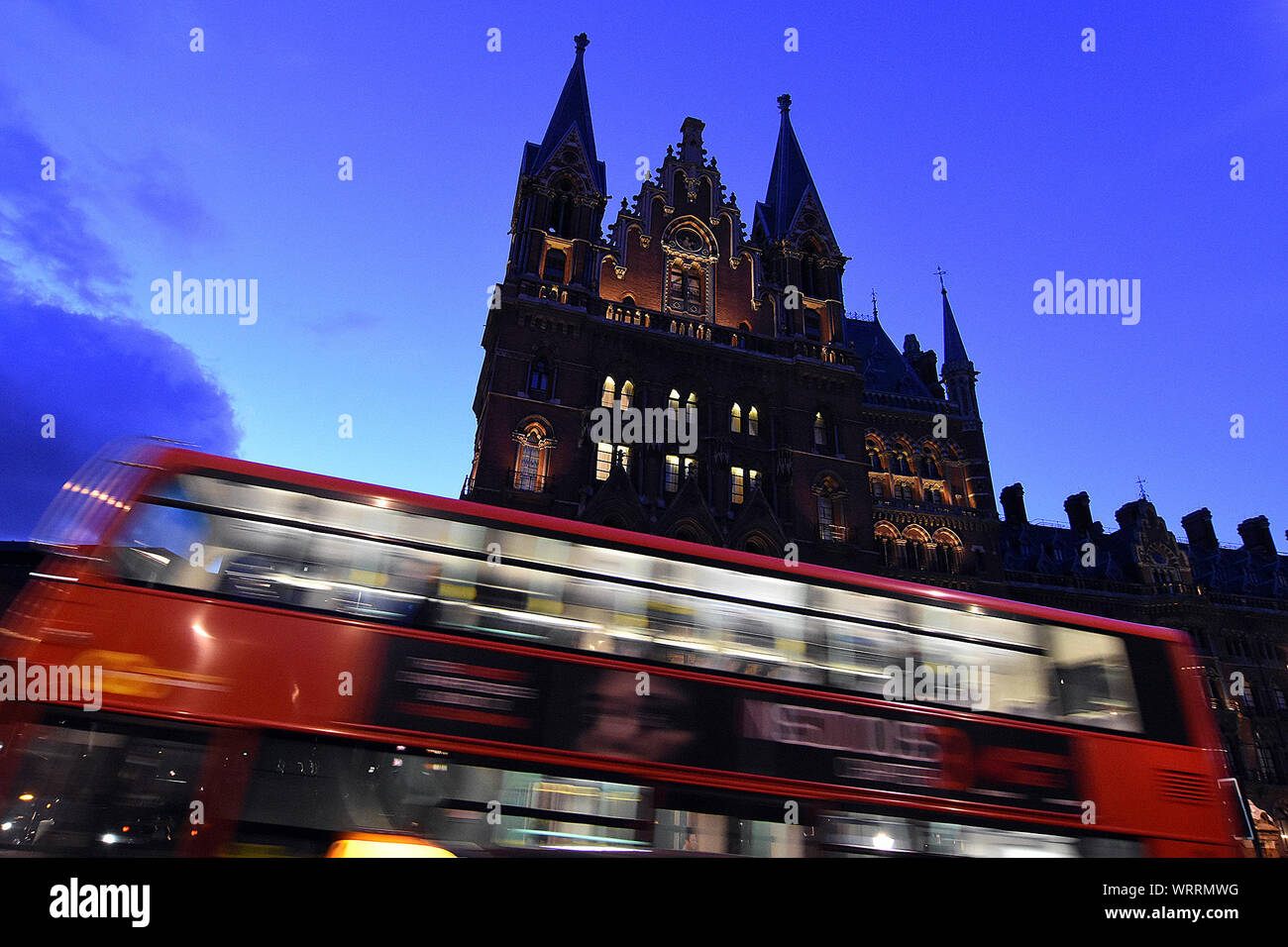 Blurred Motion Of Double-decker Bus By Church At Dusk Stock Photo