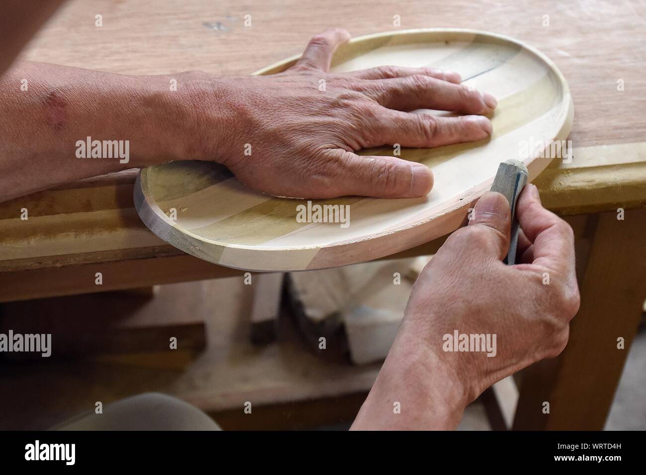 Cropped Image Of Craftsperson Shaping Wood At Workshop Stock Photo