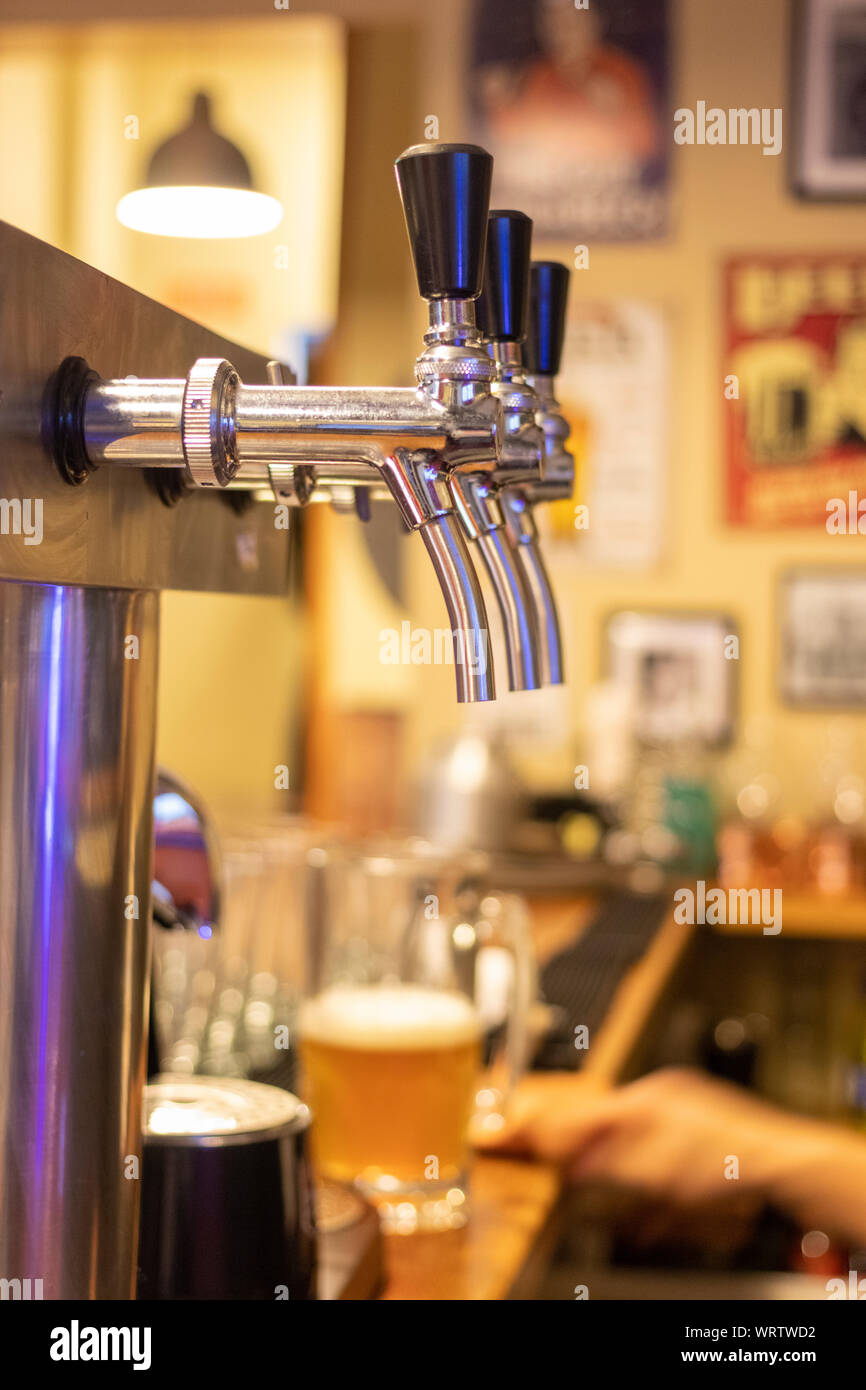Hand of bartender pouring a large lager beer in tap. Stock Photo